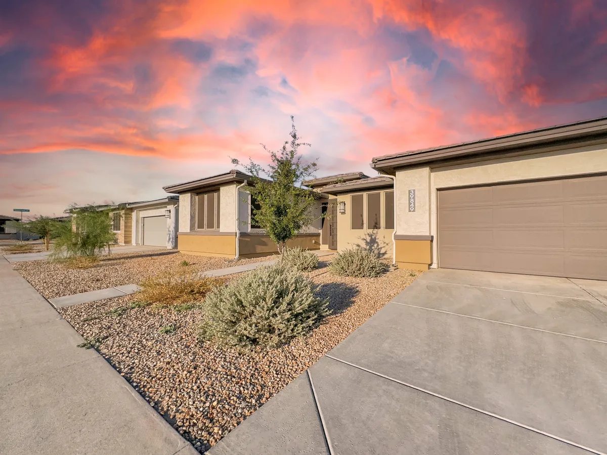 An inviting exterior shot showcasing the home's front entrance at sunset, with warm light washing over the landscaped gravel area. The scene hints at tranquil evenings and easy access to the outdoors, setting a relaxing tone for the living environment.